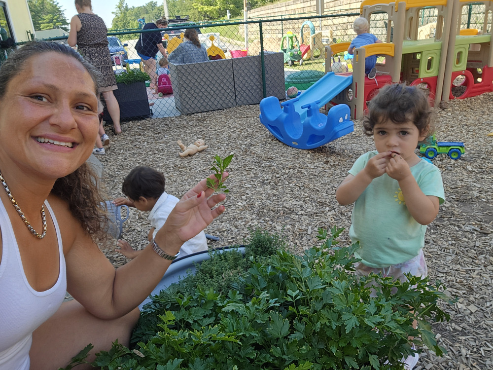 Teacher and child exploring garden plants