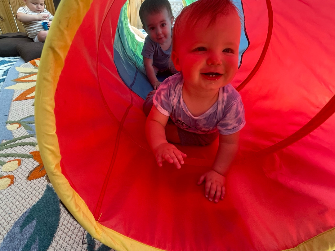 Infants and toddlers playing in colorful tunnel